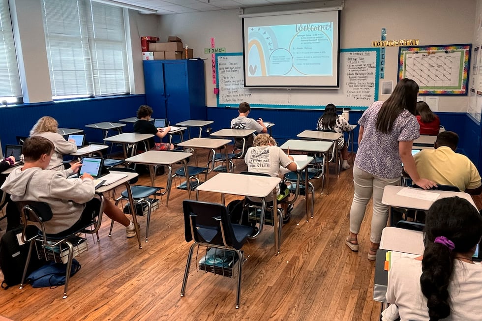 Math teacher Cheyenne Crider helps a seventh-grade student with a math problem at Piedmont...