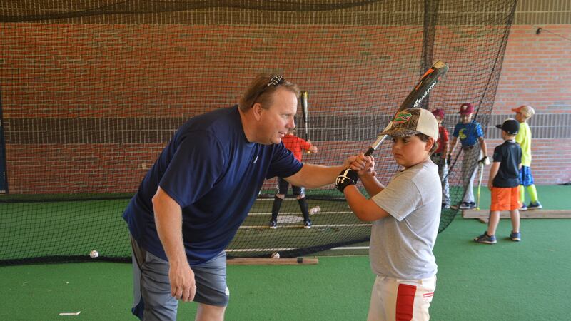 Chipola Coach Johnson teaches a young player at a baseball camp. (Source: Chipola Athletics)