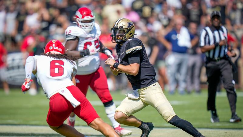 Purdue quarterback Hudson Card (1) runs with the ball in front of Fresno State linebacker...