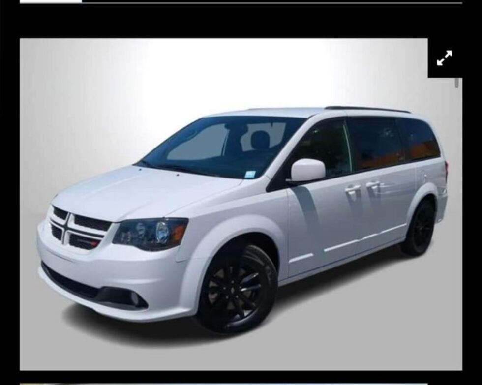 The van has a luggage rack on the top and a Fuel Flex sign on the back right
