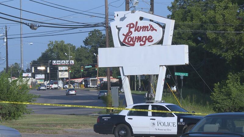 A Dothan police car sits under the sign at Plum's Lounge where a man was shot to death in July...