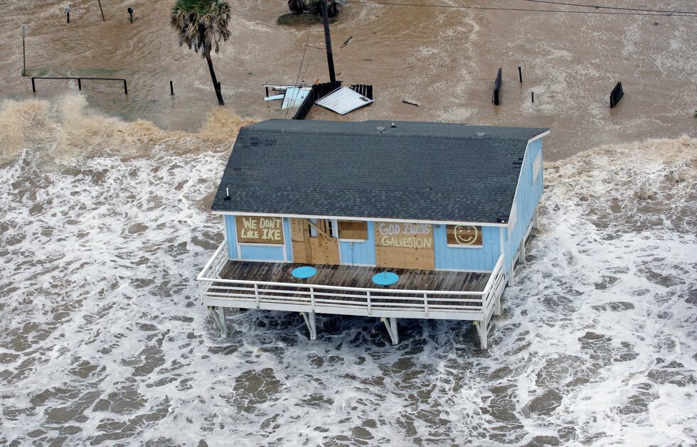 FILE - In this Sept. 12, 2008, file photo, a boarded-up home sits along the beach as Hurricane...